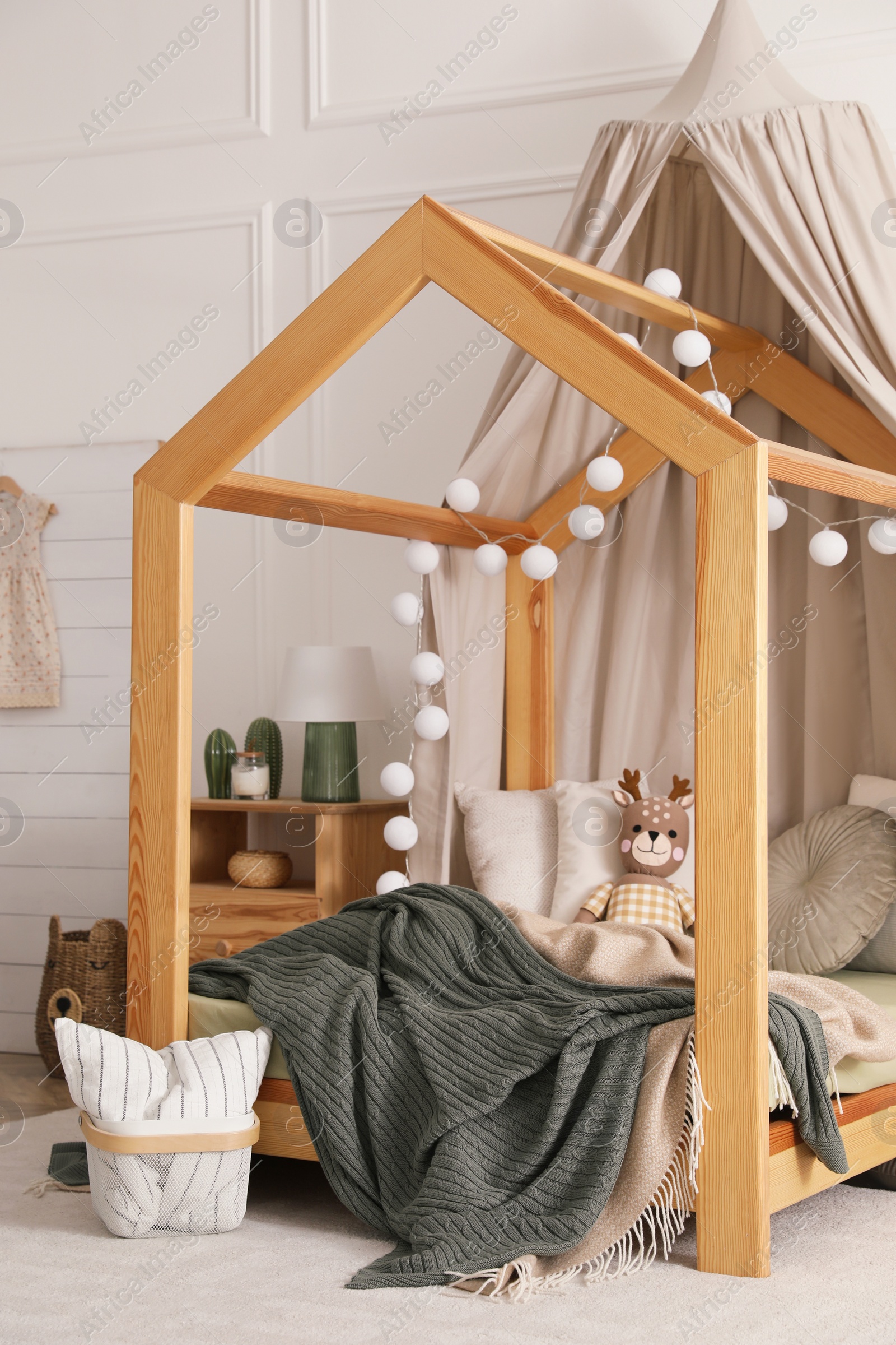 Photo of Stylish child room interior with wooden house bed