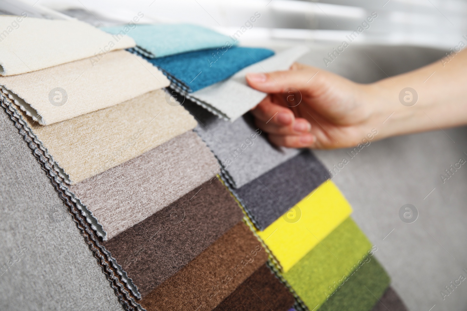 Photo of Woman choosing fabric among colorful samples on sofa, closeup