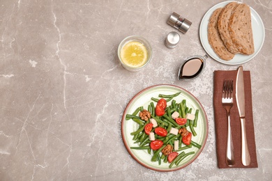 Photo of Flat lay composition with tasty green beans, cheese, nuts and tomatoes on grey background