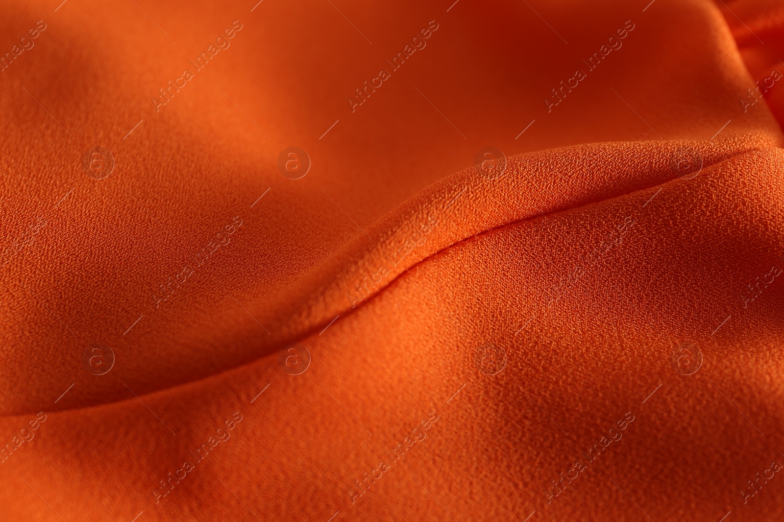 Photo of Texture of orange crumpled fabric as background, closeup view
