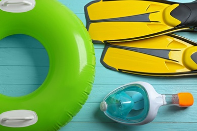 Flat lay composition with beach accessories on light blue wooden background
