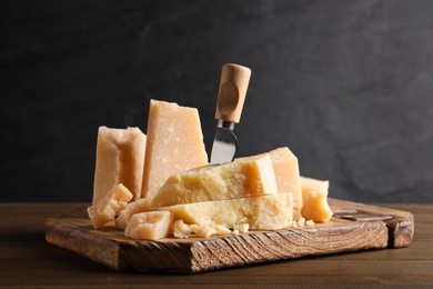 Parmesan cheese with board and knife on wooden table