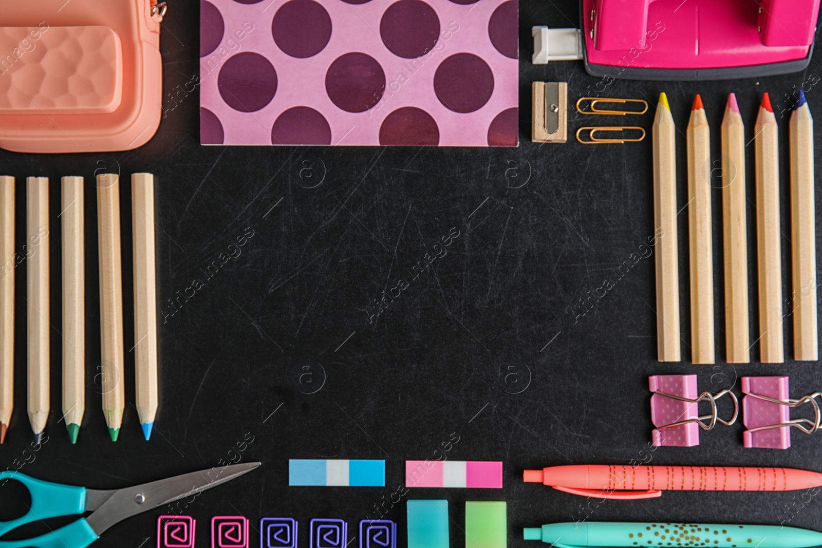 Photo of Flat lay composition with different school stationery on chalkboard surface