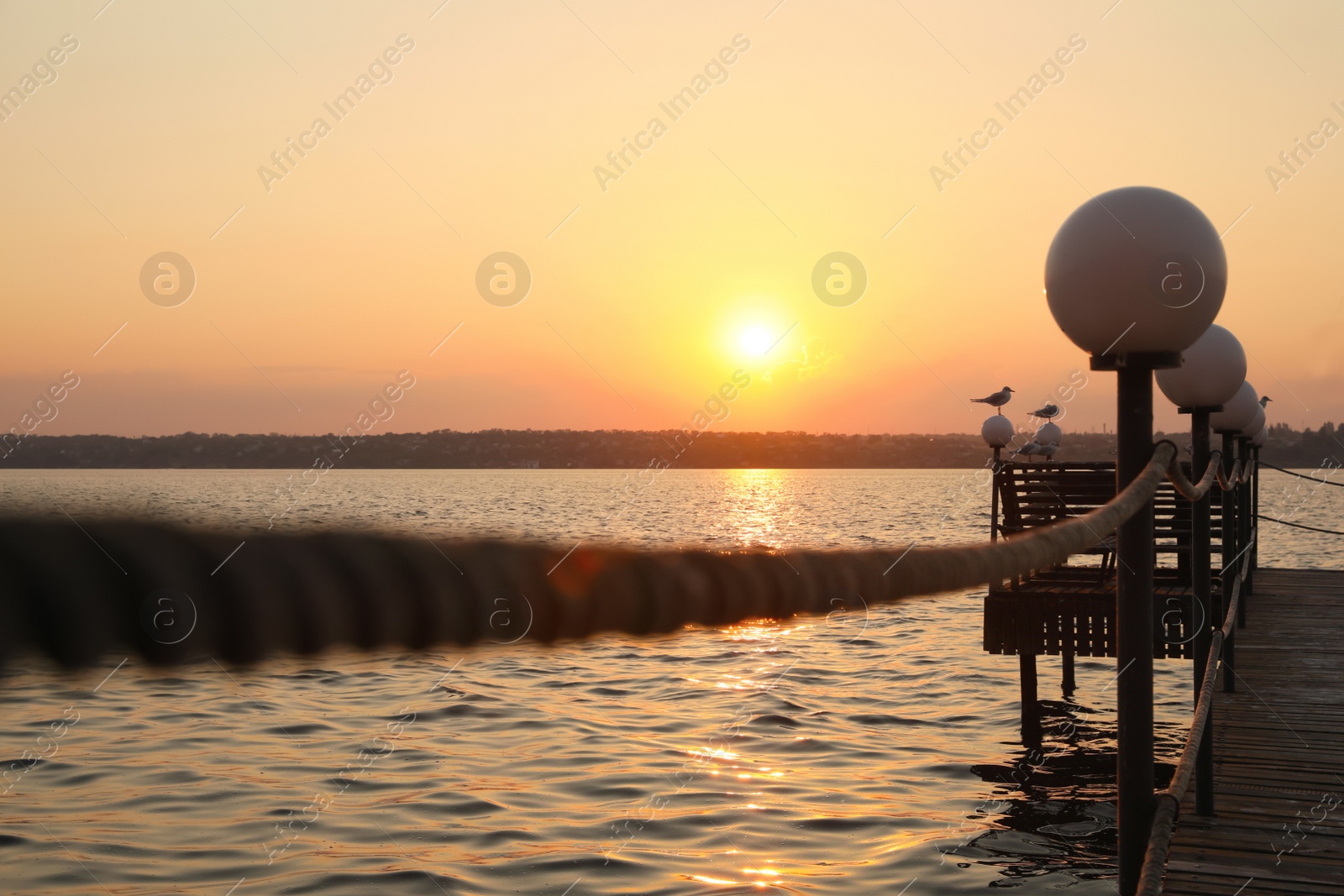 Photo of Picturesque view of beautiful river from pier at sunset