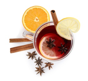 Photo of Glass cup of mulled wine, orange and cinnamon sticks on white background, top view