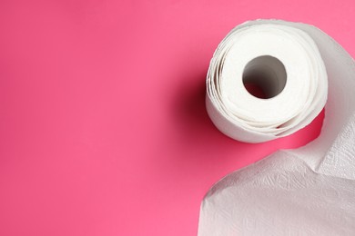 Photo of Roll of white paper towels on pink background, top view. Space for text