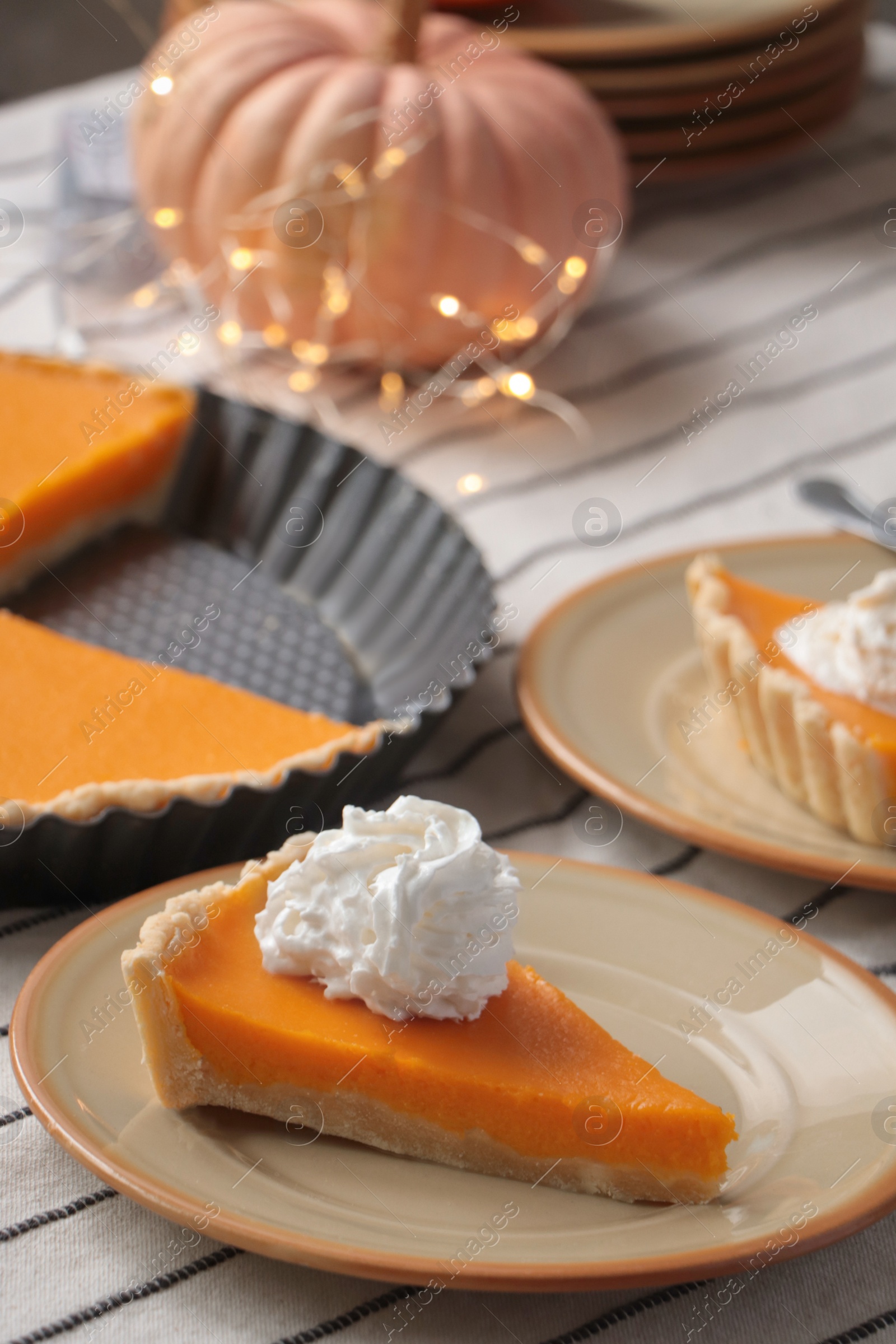 Photo of Fresh homemade pumpkin pie with whipped cream on table