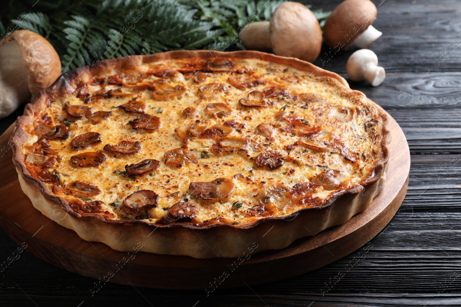 Photo of Delicious homemade mushroom pie on black wooden table, closeup