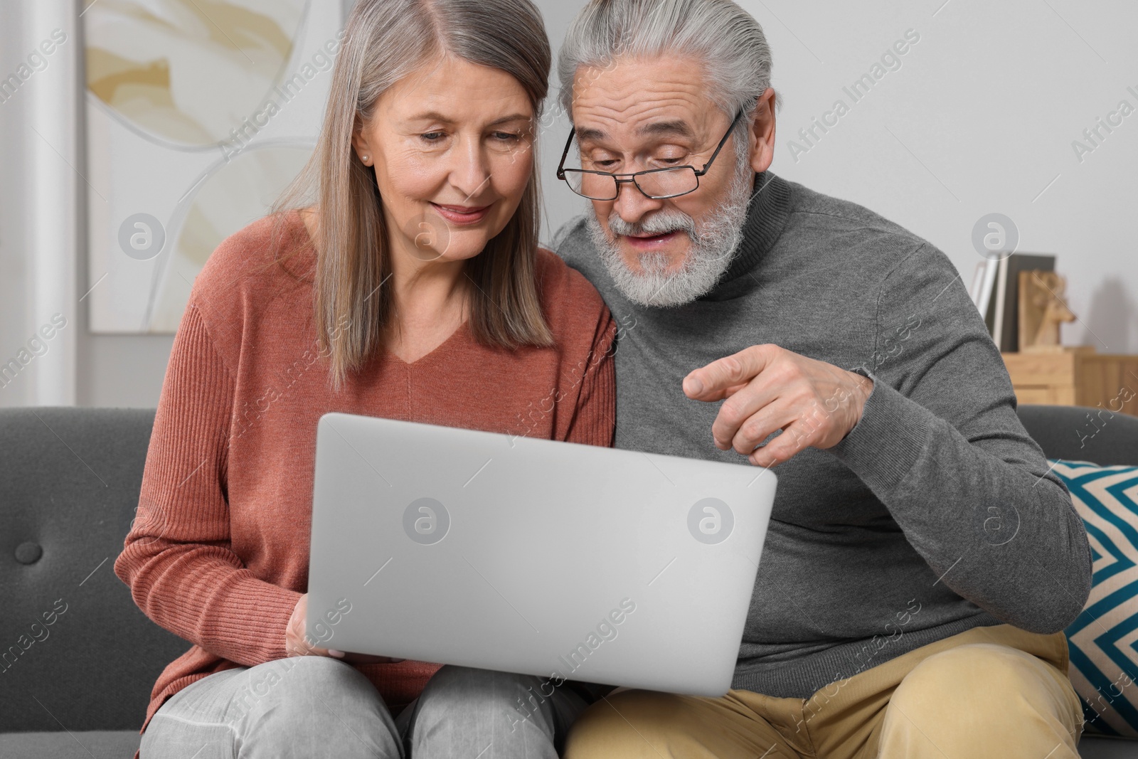 Photo of Elderly couple with laptop discussing pension plan in room