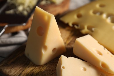 Grated and cut cheese on wooden table, closeup