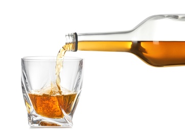 Pouring expensive whiskey into glass on white background