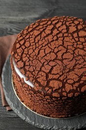 Photo of Delicious chocolate truffle cake on black wooden table