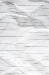 Photo of Crumpled lined notebook sheet as background, top view