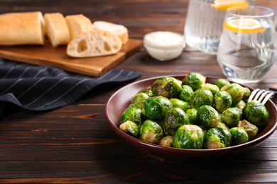 Photo of Delicious roasted Brussels sprouts on wooden table