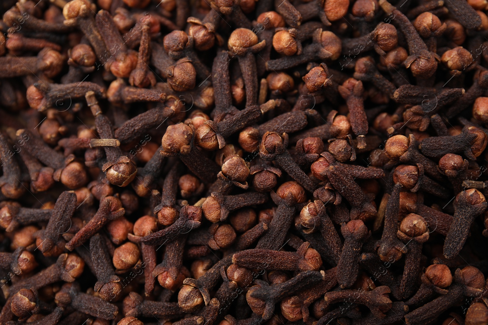 Photo of Many aromatic cloves as background, top view