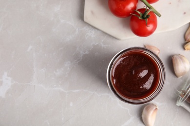 Photo of Flat lay composition with jar of barbecue sauce on grey background. Space for text