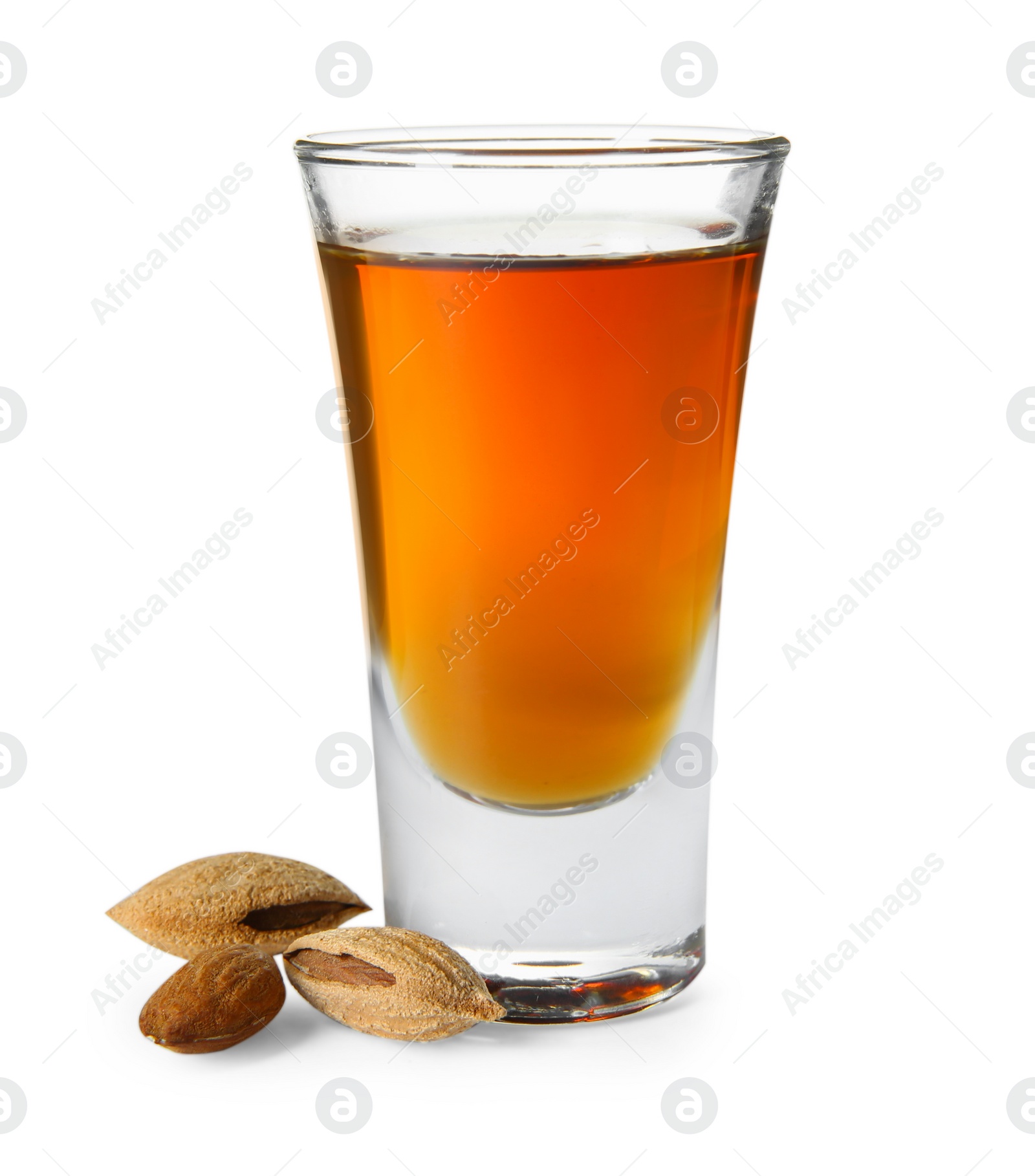 Photo of Shot glass with tasty amaretto liqueur and almonds isolated on white