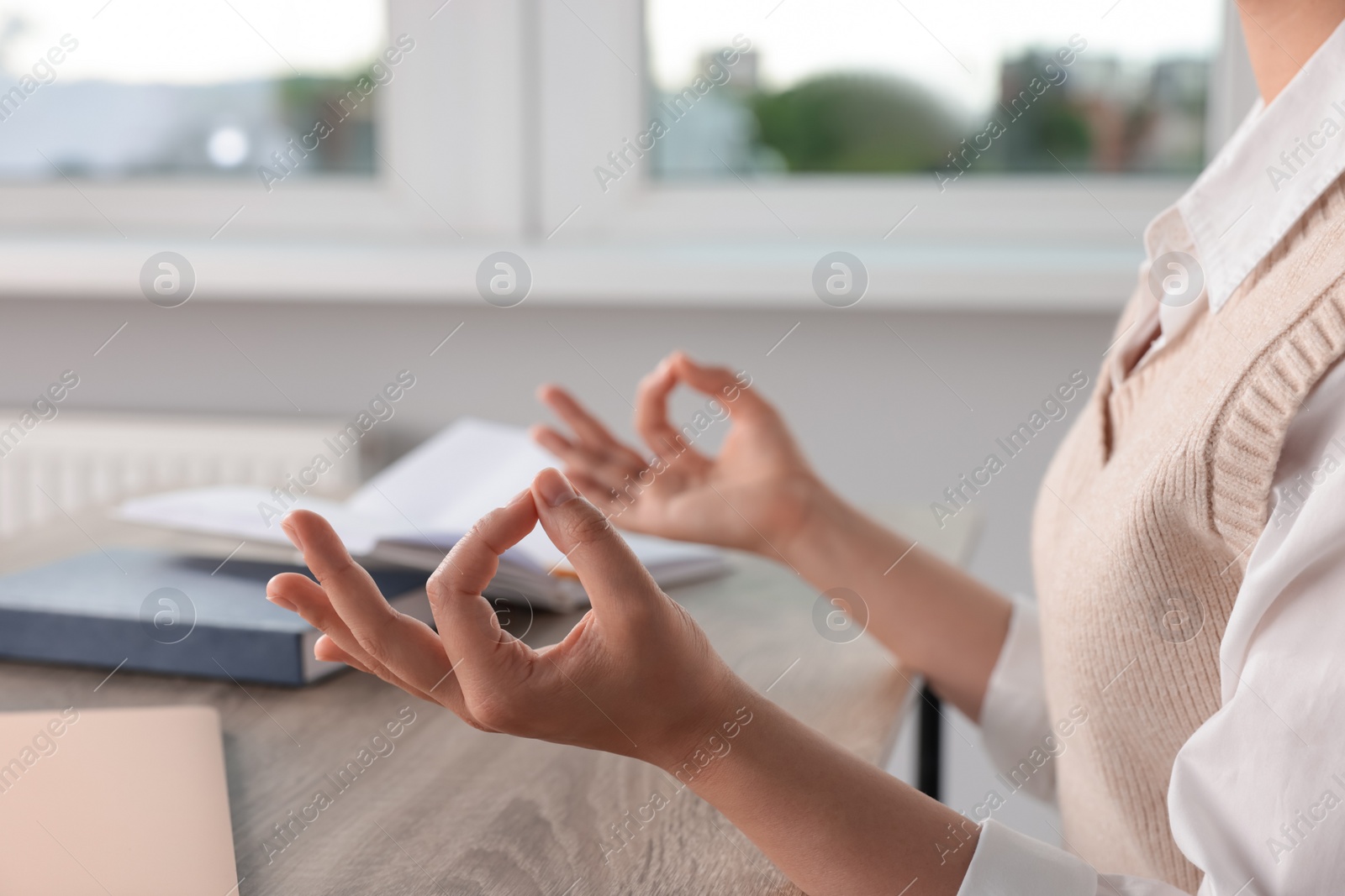 Photo of Find zen. Woman taking break from work at table in room, closeup