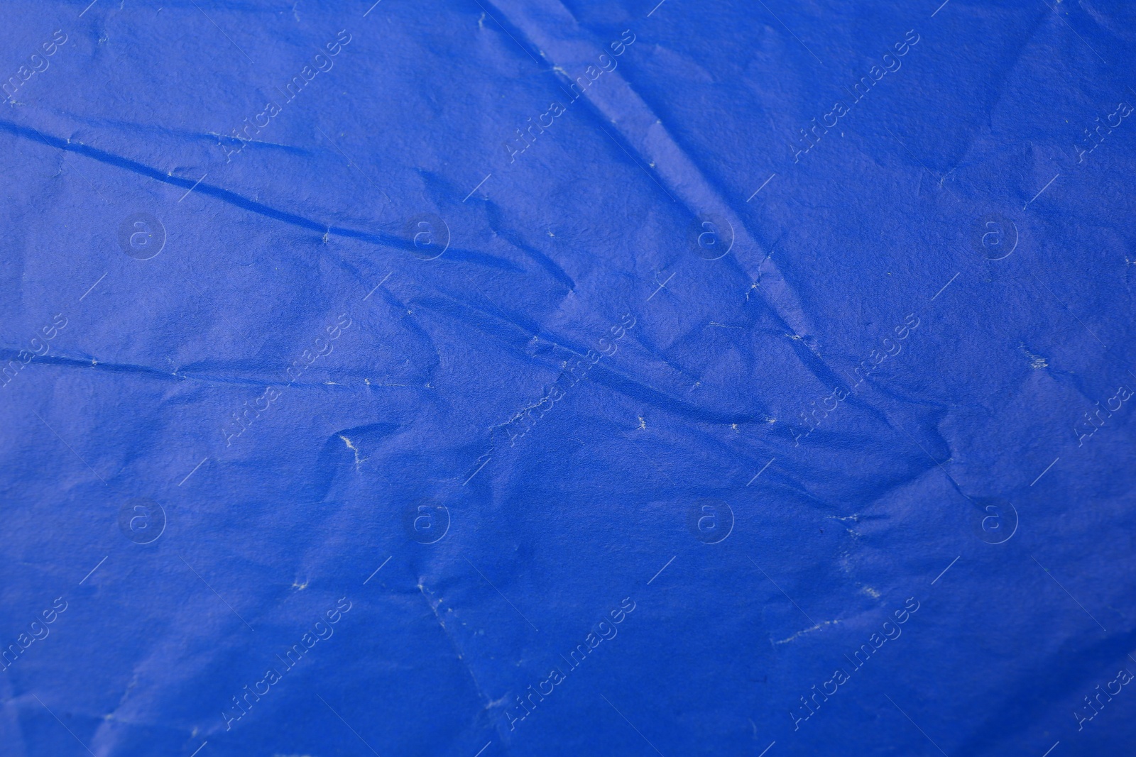 Photo of Sheet of crumpled blue paper as background, top view