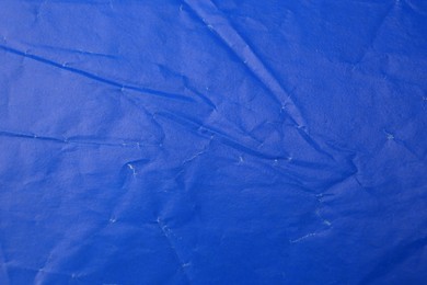 Sheet of crumpled blue paper as background, top view