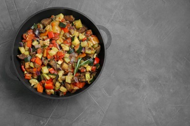 Delicious ratatouille in baking dish on grey table, top view. Space for text