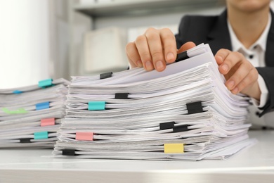 Photo of Woman working with documents at table in office, closeup