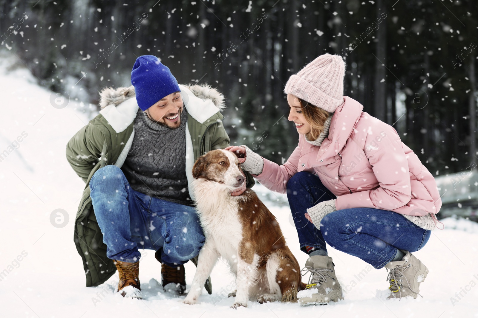 Photo of Cute couple with dog outdoors. Winter vacation