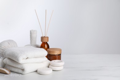 Photo of Spa composition with care products on white marble table. Space for text