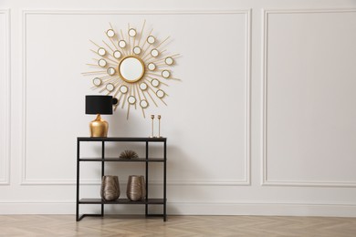 Photo of Console table near white wall with mirror in hallway, space for text. Interior design