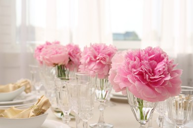 Stylish table setting with beautiful peonies indoors. Space for text
