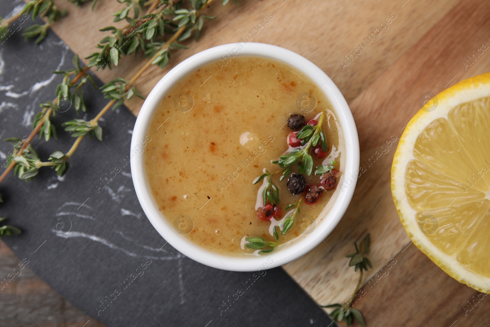 Photo of Delicious turkey gravy, thyme and peppercorns on table, top view