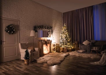 Photo of Stylish interior with beautiful Christmas tree and artificial fireplace at night