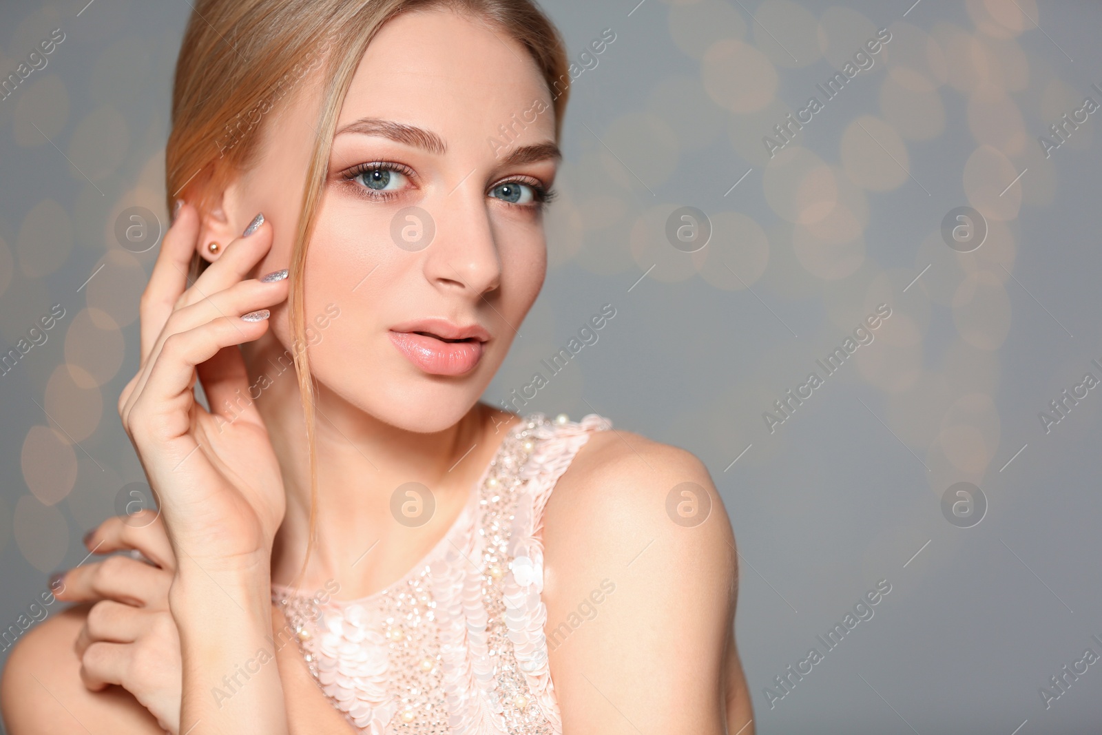 Photo of Beautiful young woman with shiny manicure on blurred background, space for text. Nail polish trends