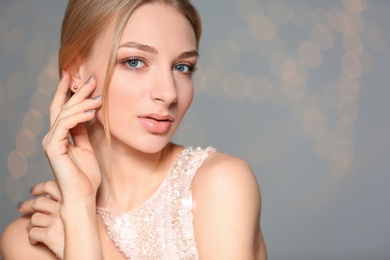 Photo of Beautiful young woman with shiny manicure on blurred background, space for text. Nail polish trends