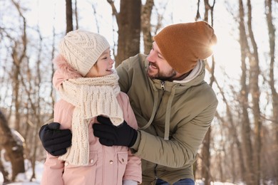 Family time. Happy father and his daughter in snowy forest