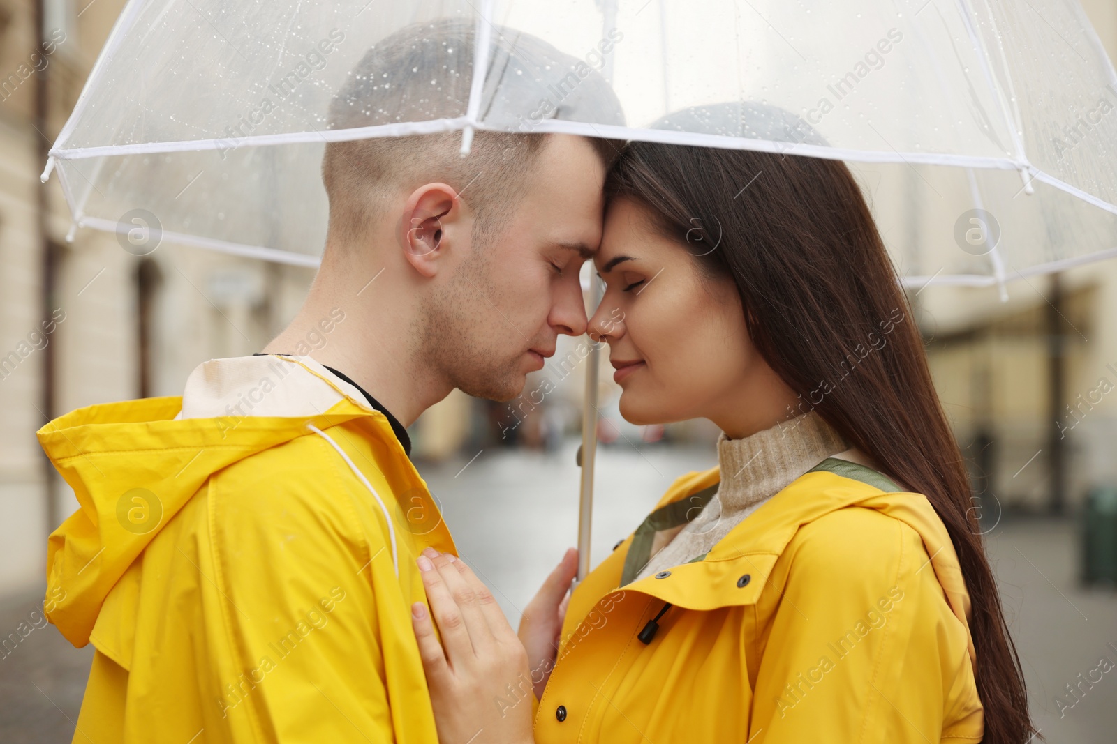 Photo of Lovely young couple with umbrella on city street