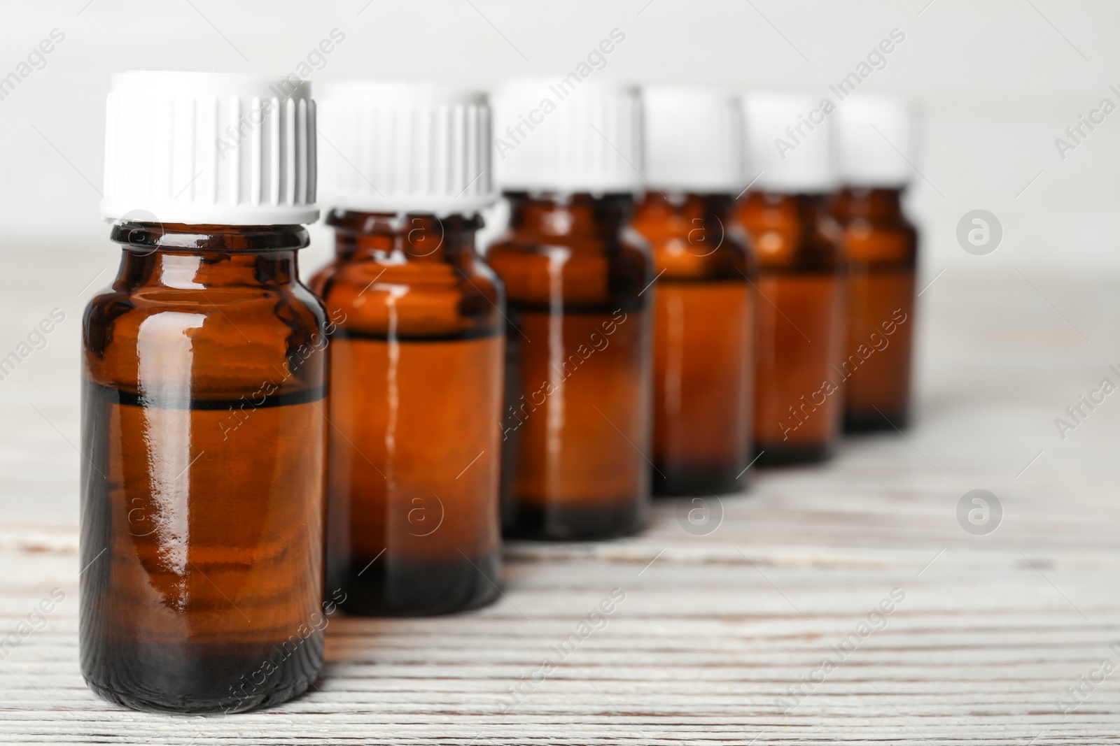 Photo of Glass bottles with essential oil on wooden table