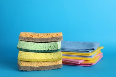 Photo of Color sponges and rags on light blue background