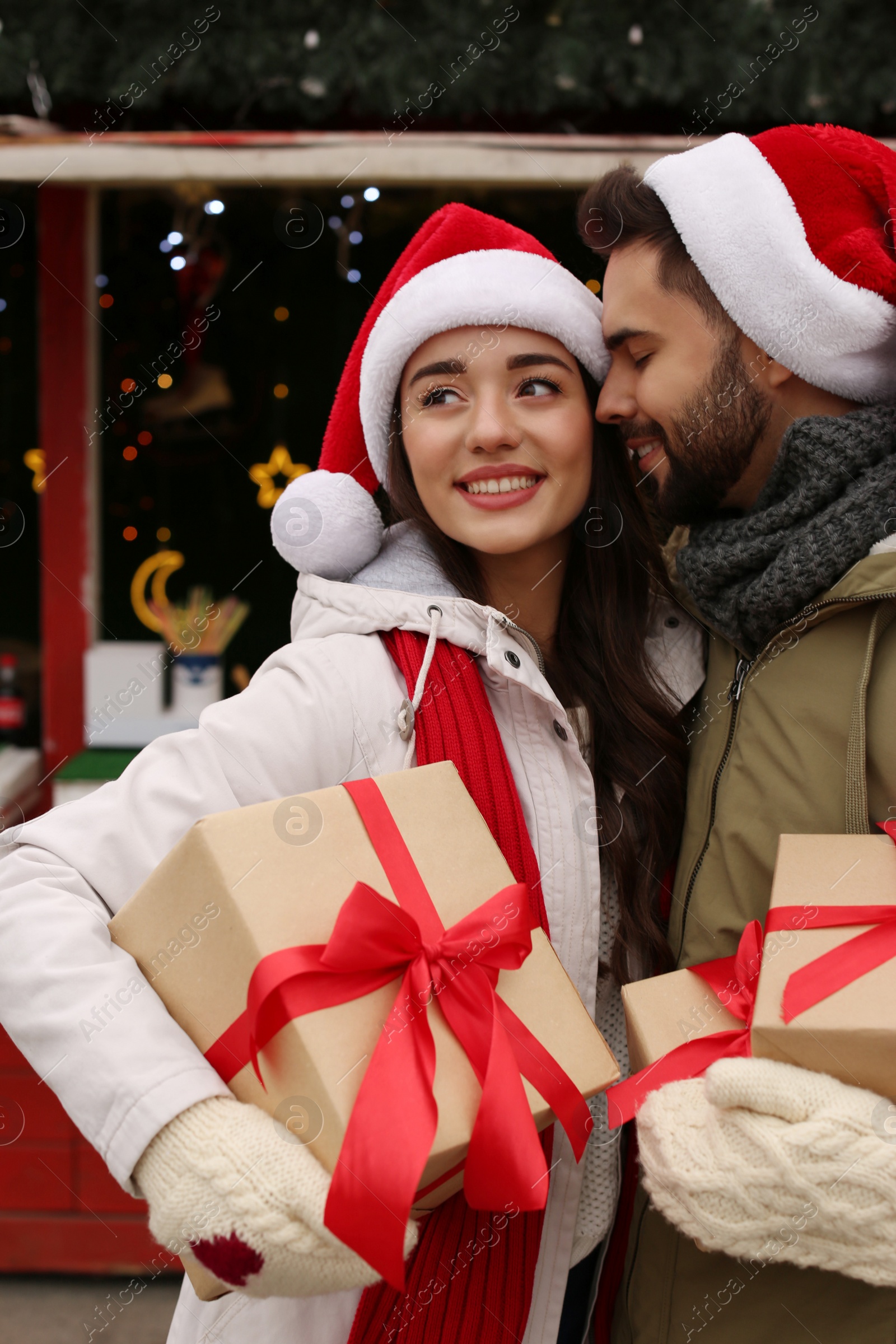 Photo of Lovely couple with Christmas presents at winter fair