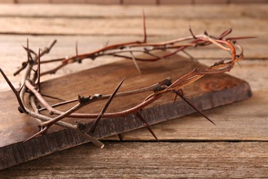 Photo of Crown of thorns on wooden table, closeup