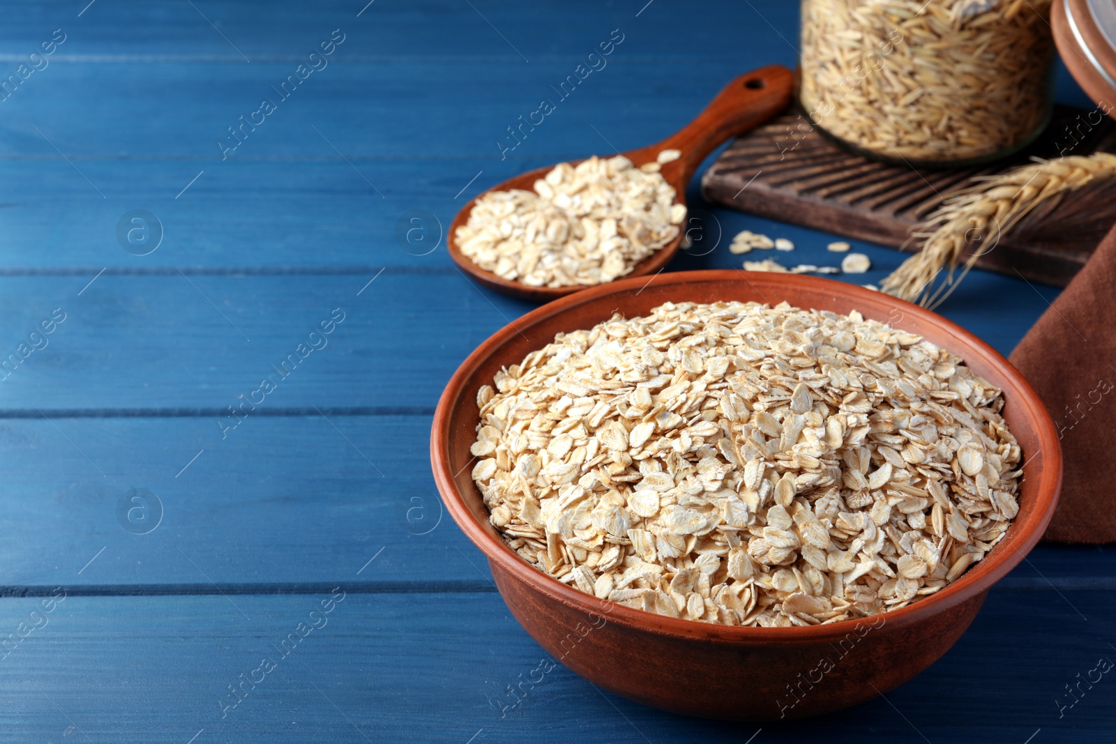 Photo of Bowl of oatmeal on blue wooden table, space for text