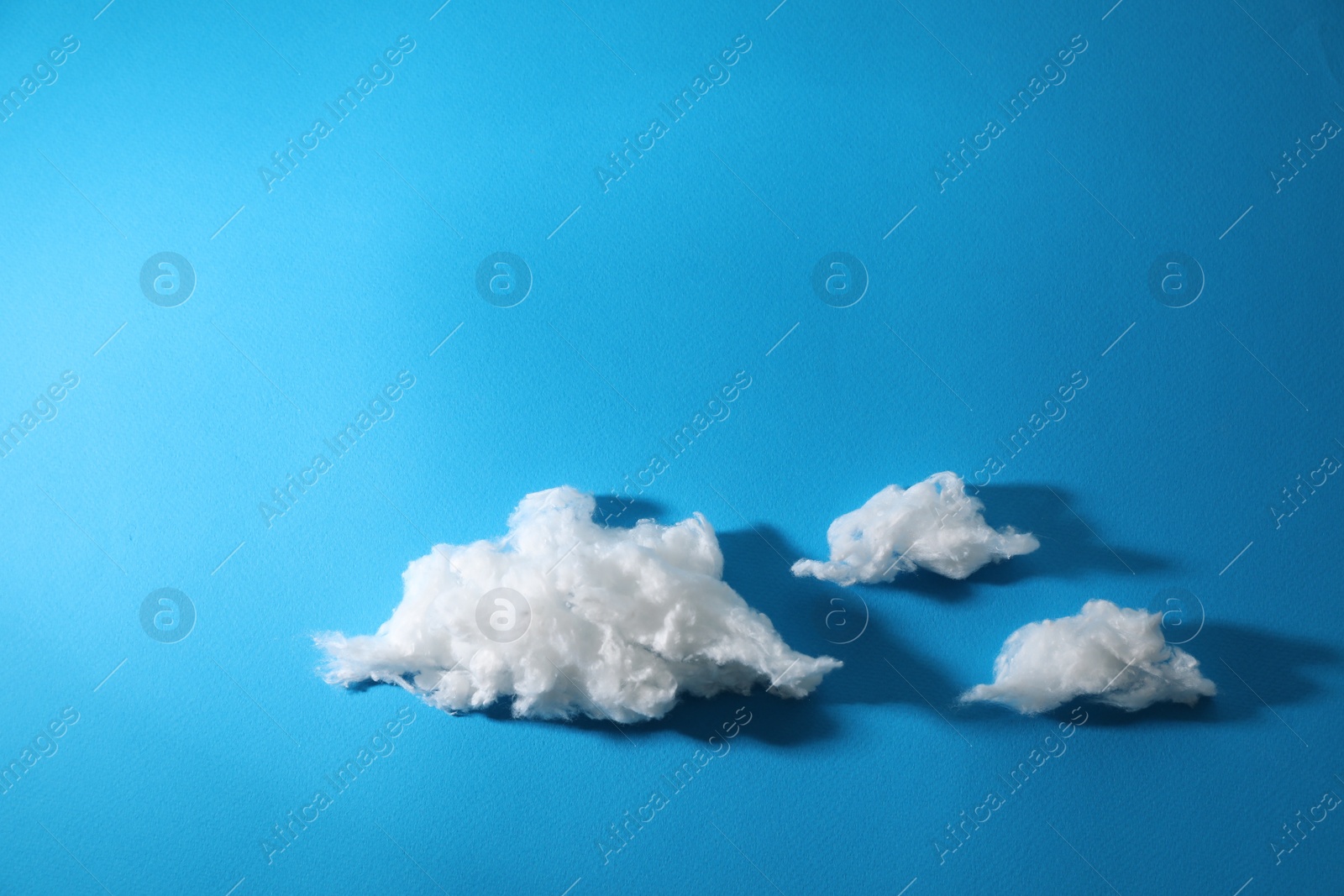 Photo of Clouds made of cotton on blue background. Space for text