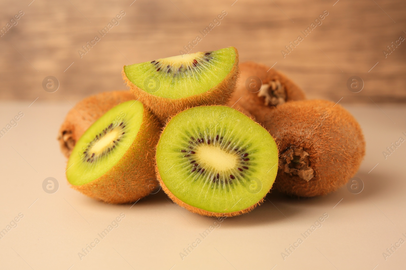 Photo of Heap of whole and cut fresh kiwis on white background, closeup