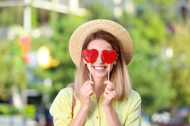 Photo of Beautiful smiling woman with candies on city street