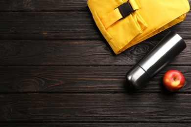 Photo of Flat lay composition with thermos on black wooden background, space for text