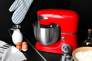 Photo of Modern stand mixer and ingredients on countertop in kitchen