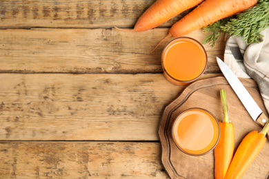 Photo of Freshly made carrot juice on wooden table, flat lay. Space for text