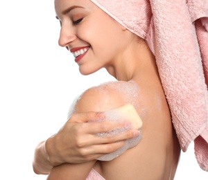 Young woman washing body with soap bar on white background, closeup