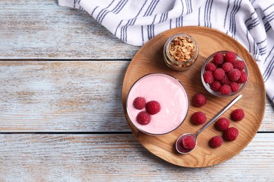 Photo of Tray with delicious yogurt, raspberries and granola on old wooden table, top view. Space for text