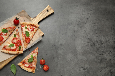 Slices of delicious pizza Margherita on grey table, flat lay. Space for text